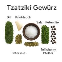 Zutaten des Tzatziki Gewürzes nebeneinander auf weißem Untergrund arrangiert: getrockneter Dill, Schnittlauch, Petersilie, Knoblauch, Zwiebel, Pfefferkörner, Oregano, Salz.