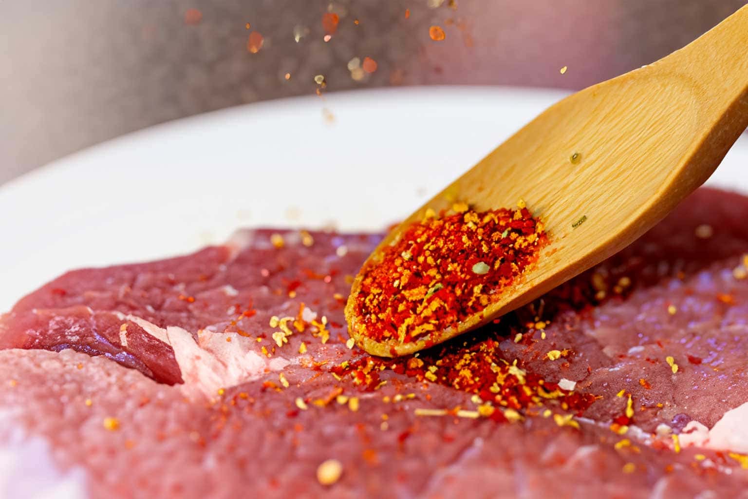 cajun-dosierung Cajun Gewürz wird über Fleisch gestreut